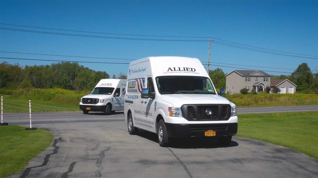 The company trucks for allied heating and air conditioning pulling into a driveway